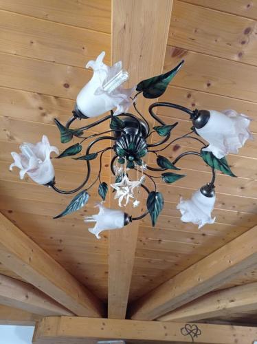 a chandelier with white flowers hanging from a ceiling at Chalet du soleil in Odecla