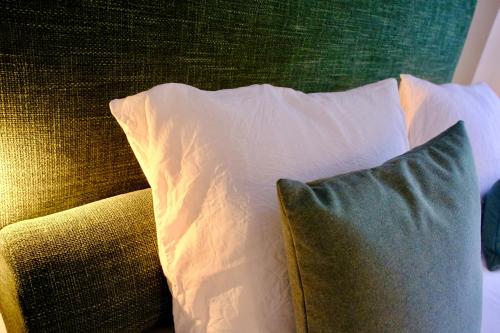 a green couch with two pillows on it at La Dominotte short stay apartment 9a in Arcen