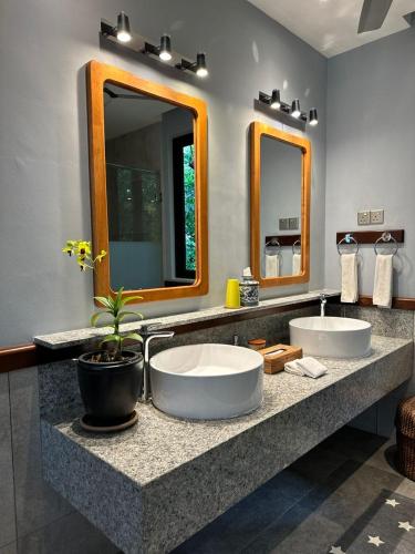 a bathroom with two sinks and two mirrors at Ambong Pool Villas - Private Pool in Pantai Cenang
