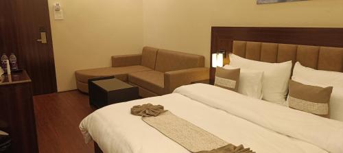 a hotel room with a bed and a chair at XCELSIOR HOTEL AND SPA by ROH in Shillong
