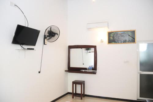a mirror and a tv on a wall at Royal Inside Hotel in Udawalawe