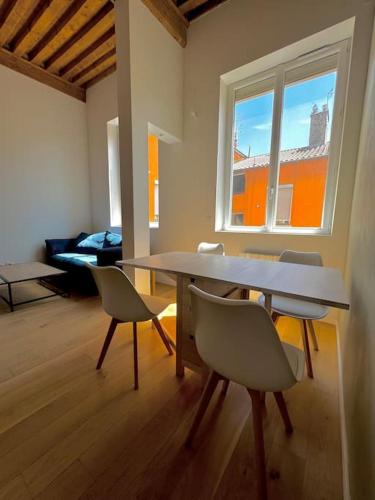 un salon avec une table et des chaises et une fenêtre dans l'établissement Charmant T3 - Place Colbert - Lyon Centre, à Lyon