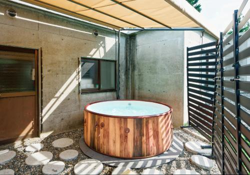 a hot tub on the patio of a house at Togari Inn Suites in Iiyama