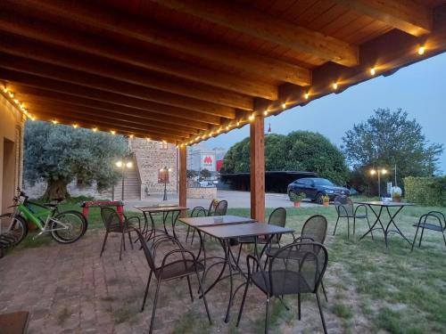 a patio with tables and chairs under a wooden pergola at Alba su Assisi in Petrignano