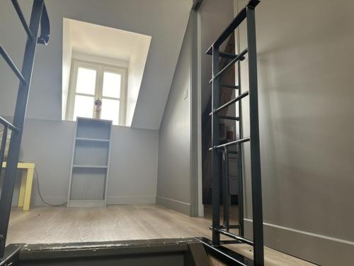 an empty room with a ladder and a window at La Maison du Chablisien in Chablis