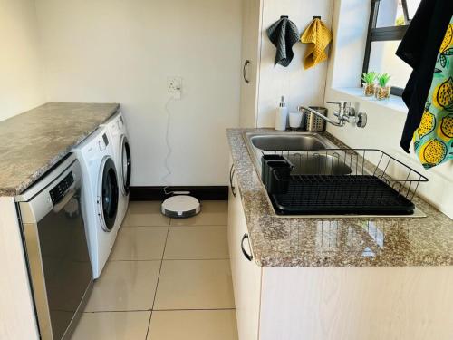 a kitchen with a sink and a washing machine at Round Robben in Langebaan