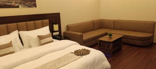a hotel room with a bed and a couch at XCELSIOR HOTEL AND SPA by ROH in Shillong