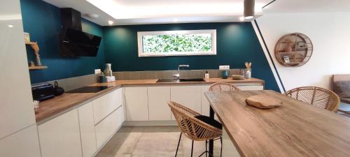 une cuisine avec une table, des chaises et un évier dans l'établissement Cadre Verdoyant & Plage à Pied, au calme, à Le Minihic-sur-Rance
