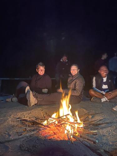 eine Gruppe von Menschen sitzt um ein Feuer herum in der Unterkunft Mount Batur camping in Kubupenlokan