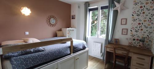 une chambre avec un lit, un bureau et une fenêtre dans l'établissement Cadre Verdoyant & Plage à Pied, au calme, à Le Minihic-sur-Rance