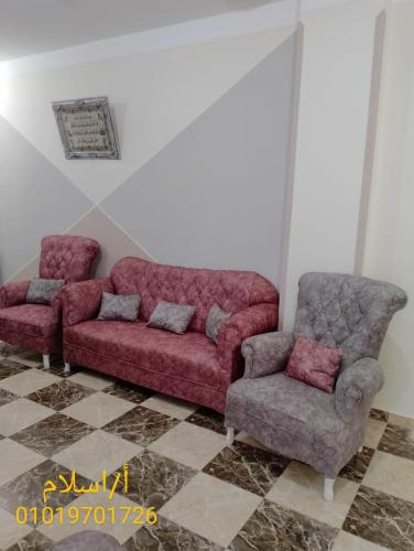 a couch and a chair in a room at برج القط للشقق الفندقيه المفروشة in Marsa Matruh