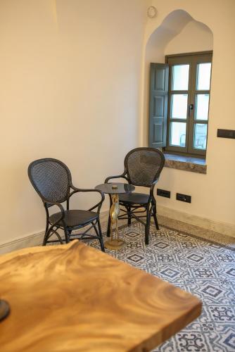 a room with three chairs and a table and a mirror at La Maltese Estate in Imerovigli