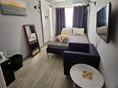 a small room with a bed and a couch at Guest House Casa Ramos on the Strip in Albufeira