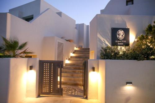 a house with a gate and stairs with lights at La Maltese Estate in Imerovigli