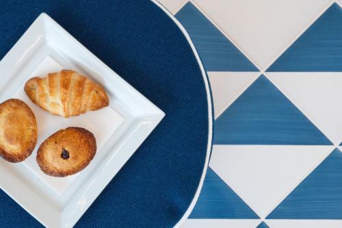 two donuts on a white plate on a table at Hotel La Roccia in Castro di Lecce