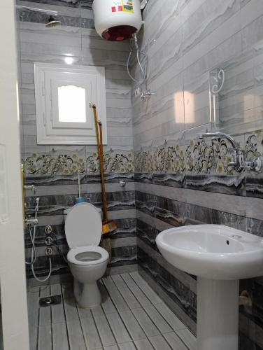 a bathroom with a toilet and a sink at برج القط للشقق الفندقيه المفروشة in Marsa Matruh