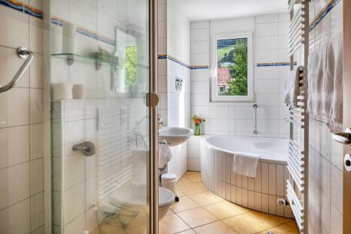 a bathroom with a tub and a toilet and a sink at Ferienwohnung am Neumagen in Staufen im Breisgau