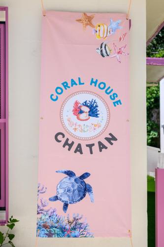 a sign for coral houses charity hanging on a wall at 最大10名 北谷アメリカンビレッジ8分 宮城海岸4分の長期滞在におすすめ コーラルハウス北谷 in Chatan