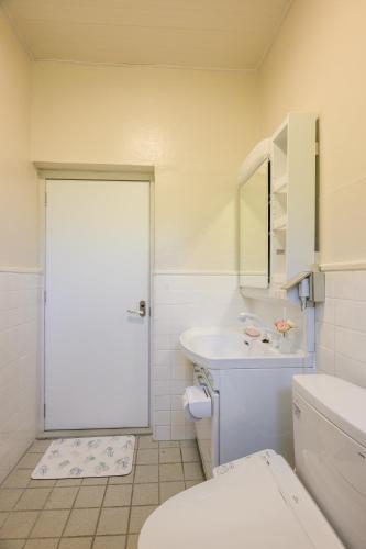 a white bathroom with a toilet and a sink at 最大10名 北谷アメリカンビレッジ8分 宮城海岸4分の長期滞在におすすめ コーラルハウス北谷 in Chatan