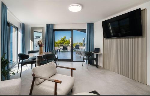 a living room with a tv and a table and chairs at SeeSea Hotel in Vodice