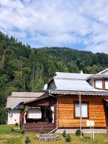a house with a solar panel on top of it at Садиба у Курила з сауною та чаном на дровах in Shepot