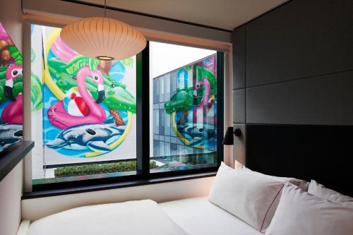 a bedroom with a bed and two windows with flamingos at citizenM Miami South Beach in Miami Beach