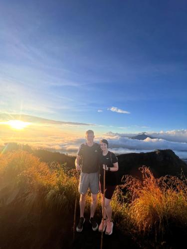 ein Mann und eine Frau stehen auf einem Berggipfel in der Unterkunft Mount Batur camping in Kubupenlokan