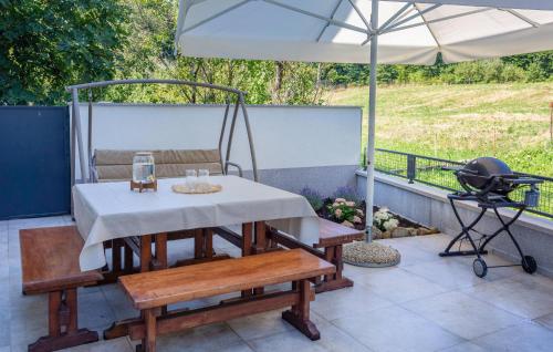 a patio with a table and a grill and an umbrella at 1 Bedroom Nice Home In Lukezi in Lukeži