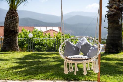a swinging chair with a pillow in a yard at Studios Rania - Rania Studios & Apartments in Lassi