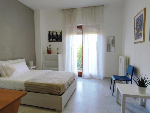 a bedroom with a bed and a chair and a window at Casa alloggio Aprìco - abitare il relax in città in Potenza