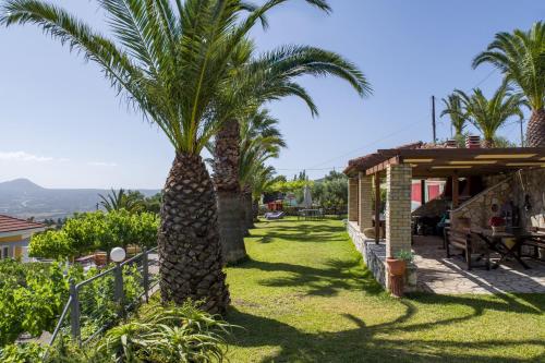 a palm tree in a yard next to a house at Studios Rania - Rania Studios & Apartments in Lassi