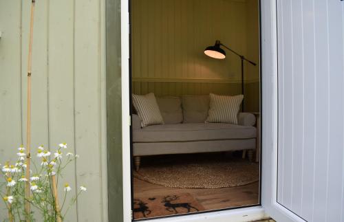 a view of a living room with a couch through a door at Ardmore Shepherd's Hut in Lochinver