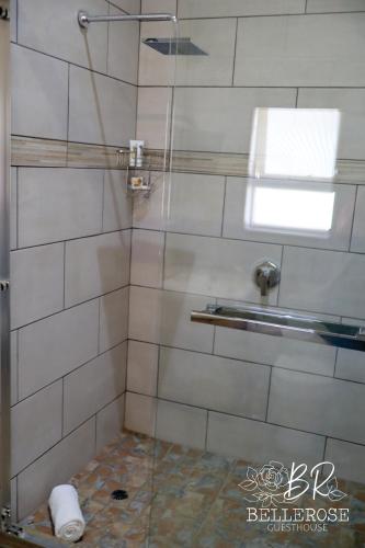 a bathroom with a shower with a glass door at Bellerose Guesthouse in Klerksdorp