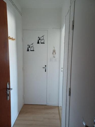 a hallway with a white room with a door at Spacieux appartement T2 & cabine in Les Angles