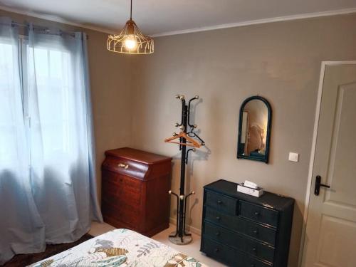 a bedroom with a bed and a dresser and a mirror at Maison à la campagne in Meursac