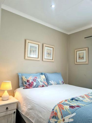 a bedroom with a bed and a table with a lamp at Point Village Accommodation - Galathea 6 in Mossel Bay