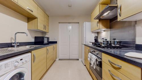a kitchen with a sink and a dishwasher at Spacious 4 Bedroom, 3 Bath House by Jesswood Properties Contractors, Business and Leisure with Free Parking and WIFI in Peterborough