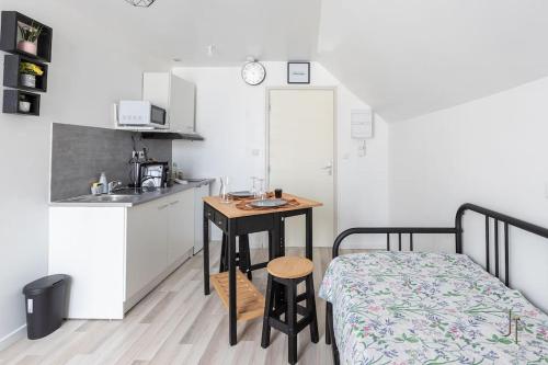 - une petite cuisine avec une table et un lit dans une chambre dans l'établissement Confortable studio tout confort, à Saint-Quentin