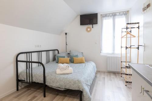 une chambre avec un lit avec deux serviettes dessus dans l'établissement Confortable studio tout confort, à Saint-Quentin