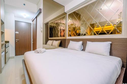 Katil atau katil-katil dalam bilik di Warm and Minimalist Studio Room Transpark Cibubur Apartment By Travelio