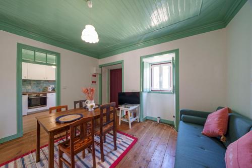 a living room with a table and a blue couch at Casa Alba, desde 1926 in Alvados