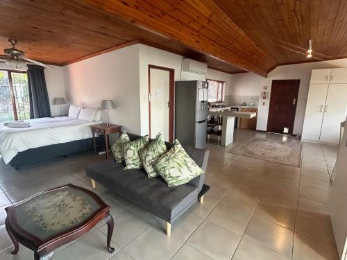Un dormitorio con una cama y un sofá y una cocina. en Sea Vista - awesome sea views, en Durban