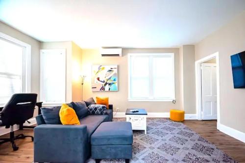 a living room with a blue couch and two windows at The Loft at Gilpin PlaceKing BedTrolley Square! apts in Wilmington