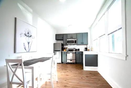 a white kitchen with a table and chairs in it at The Loft at Gilpin PlaceKing BedTrolley Square! apts in Wilmington