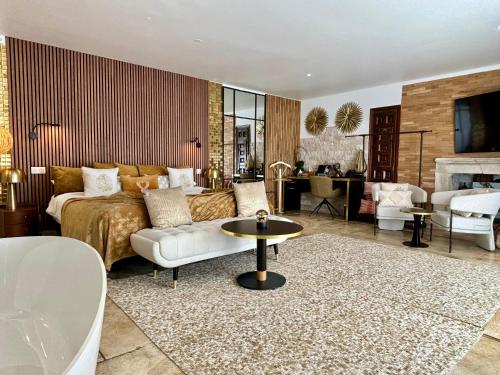 a bedroom with a bed and a living room at Le Confidentiel Hôtel & SPA in Saint-Raphaël