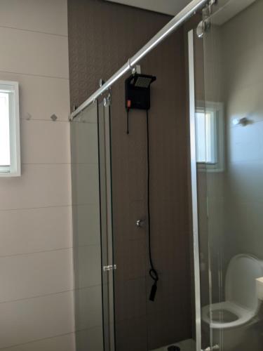 a shower with a glass door in a bathroom at Casa para Temporada No Ninho verde 1 in Quadra