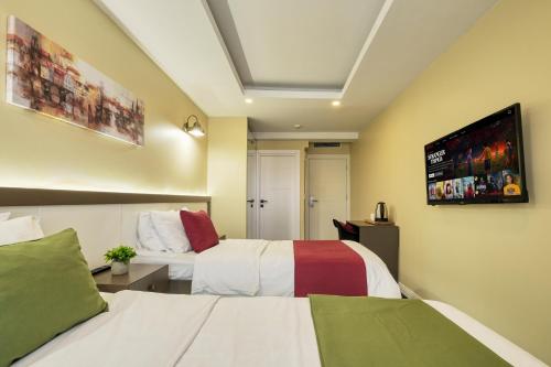 a hotel room with two beds and a flat screen tv at Duck Otel in Istanbul