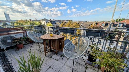 a balcony with a table and chairs on a balcony at Großzügige Maisonette über dem Leipziger Zentrum in Leipzig
