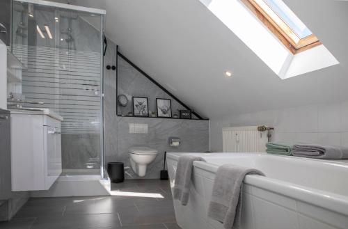 a bathroom with a bath tub and a toilet at Ferienwohnung Rheinpark Emmerich Rheinblick, Balkon & Parkplatz in Emmerich