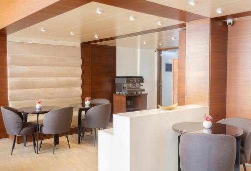 a dining room with two tables and chairs at Britannia Suites in Beirut